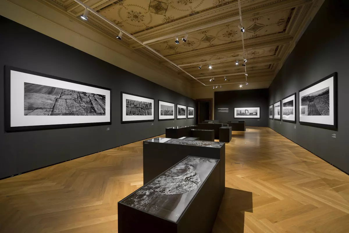 Photographies noir et blanc grand format sur des cloisons Mila-wall sombres au Musée des Arts décoratifs de Prague, devant des vitrines sombres